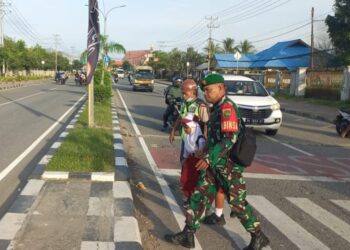 Peduli Keselamatan Anak Sekolah, Secara Rutin Babinsa Koramil Jajaran Kodim 1710/Mimika Bantu Seberangkan Jalan