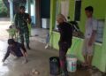 Babinsa Koramil 06 /Senayang Serda Eman Implementaskan Nilai 8 Wajib TNI, Bantu Warga Membuat Lantai Rumah