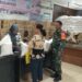 Babinsa beserta perangkat kelurahan membagikan beras dan minyak bantuan dari pemerintah